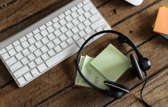 Aerial view of headphones and keyboard on wooden table